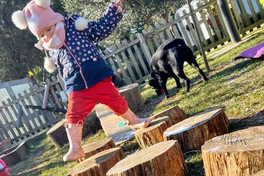 Si vede un momento di gioco: una bambina gioca tra gli ostacoli del percorso situato nel giardino del SED.
